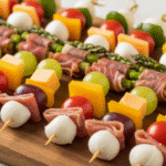 Мини-закуски на шпажках на праздничном подносе с овощами, сырами, фруктами и мясом